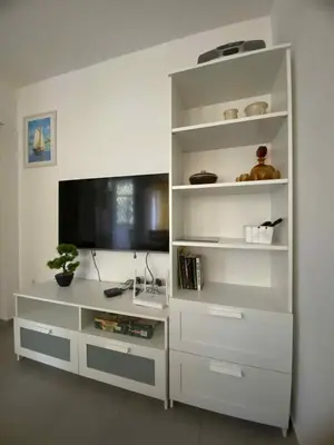 a white book shelf with a tv in a room at Уют и тишина на топ локация in Varna City