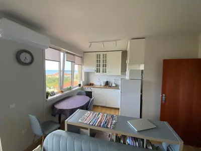 a living room with a table and a kitchen at Sea View Apartment in Byala in Byala