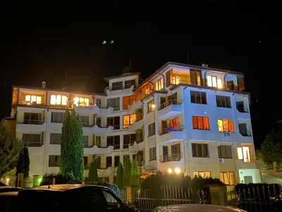 a large white building with lit up windows at night at Sea View Apartment in Byala in Byala