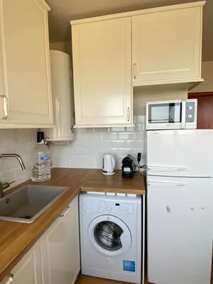a kitchen with a washing machine and a microwave at Sea View Apartment in Byala in Byala