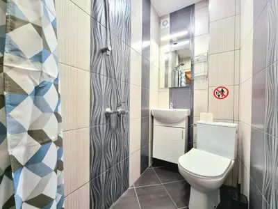 a small bathroom with a toilet and a sink at Nicky's Apartment - with Private Parking in Center in Burgas City