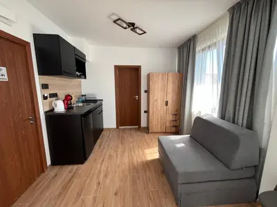 a living room with a couch and a kitchen at Къща за гости Сирената in Sozopol