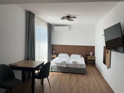 a bedroom with a bed and a table and a desk at Къща за гости Сирената in Sozopol