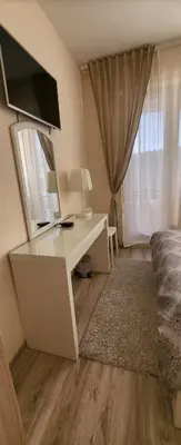 a bedroom with a desk with a television and a bed at Apartament Silvi Super View in Varna City