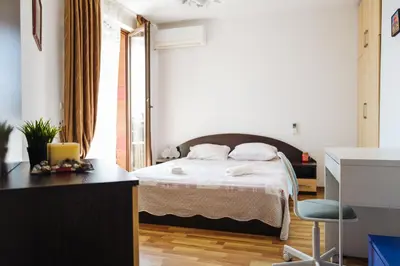 a bedroom with a bed and a desk with a chair at Mirage Collective in Nesebar