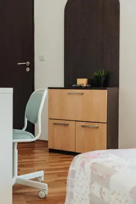 a bedroom with a wooden dresser and a chair at Mirage Collective in Nesebar