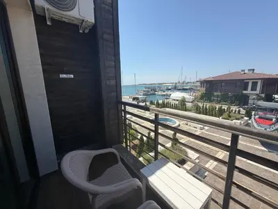a balcony with a chair and a view of the ocean at Studio Port Nessebar in Nesebar