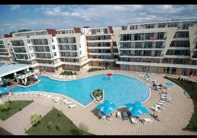 a large swimming pool in front of some apartment buildings at Уютная студия на Солнечном берегу in Sunny Beach