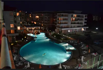 an overhead view of a large swimming pool at night at Уютная студия на Солнечном берегу in Sunny Beach