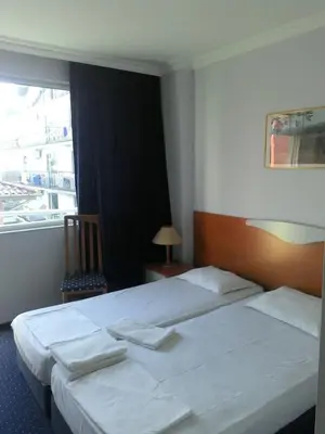 a hotel room with two beds and a window at Alexandrov Residence Studio in Nesebar