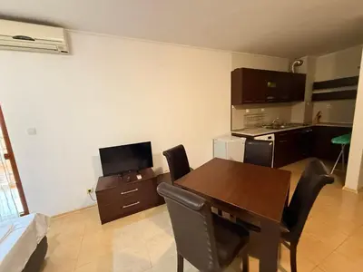 a kitchen and dining room with a table and chairs at South Beach Vigo Studio in Nesebar