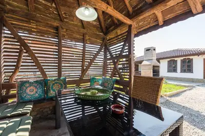 a wooden pergola with a table and chairs on a patio at Augusta's Authentic Farm House in Pchelnik