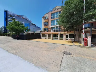 a person walking down a street next to a building at Бобс апартаменти 1 in Kiten