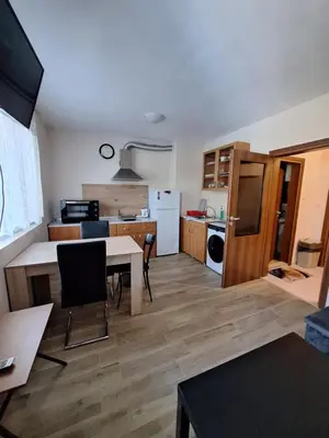 a kitchen and living room with a table and chairs at Бобс апартаменти 1 in Kiten