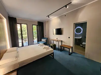 a bedroom with a large bed and a bathroom at O'clock bed & SPA in Burgas City