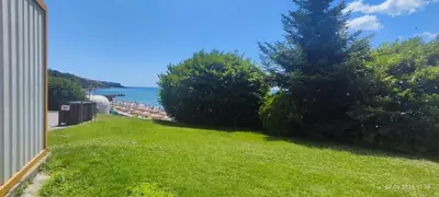 a grassy yard with a view of the water at Свети Влас Етъра1 in Sveti Vlas