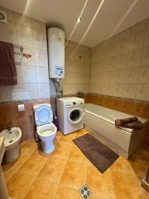 a bathroom with a toilet a sink and a washing machine at Каса Реал апартамент с 2 спальнями in Sveti Vlas