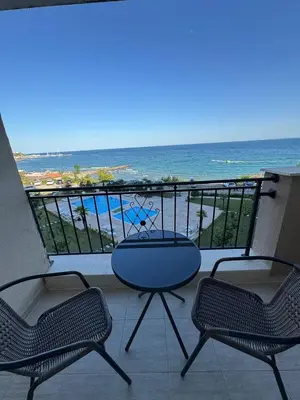 a balcony with a table and chairs and the ocean at Ипанемма апартамент с 1 спальней in Sveti Vlas