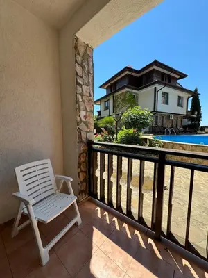 a white chair on the balcony of a house at Arena Apart in Sveti Vlas