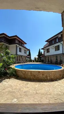 a large blue swimming pool in front of a house at Arena Apart in Sveti Vlas