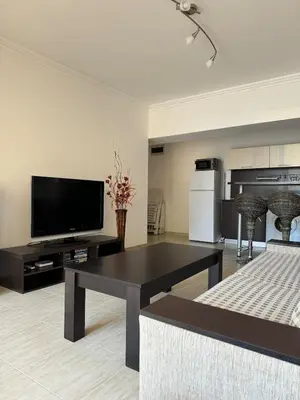 a living room with a black table and a flat screen tv at Arena Apart in Sveti Vlas
