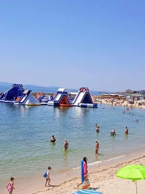 a group of people in the water at a beach at Уютная квартира в 5 минутах от пляжа in Ravda