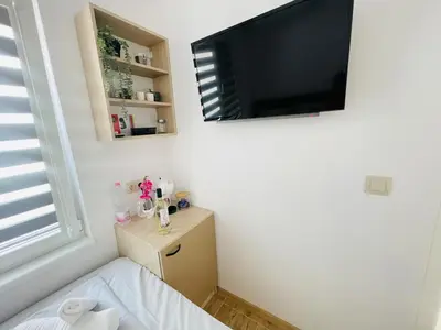a bedroom with a flat screen tv on the wall at The Secret Tale in Varna City