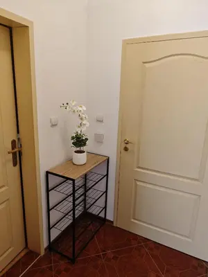 a room with a door and a table with flowers on it at SUN LIGHT Slnečné pobrežie in Sunny Beach