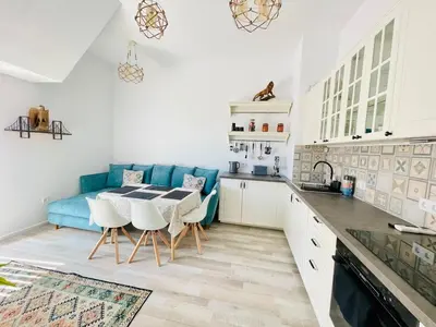 a kitchen with a table and a blue couch at 2BR Vintage Residence - free parking in Varna City
