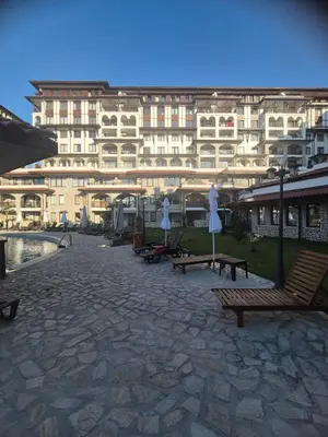 a large building with benches and umbrellas in front of it at Etara 4 in Sveti Vlas