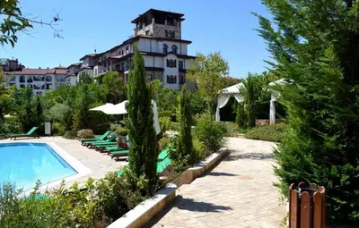 a hotel with a swimming pool in front of a building at Эстебан с 2 спальнями in Nesebar