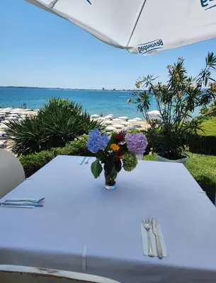 a table with a vase of flowers on top of the beach at Каса реал с 2 спальнями 2 этаж in Sveti Vlas