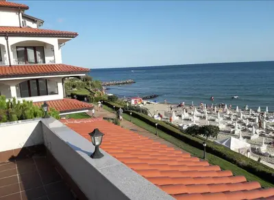 a view of a beach with umbrellas and the ocean at Каса реал с 2 спальнями 2 этаж in Sveti Vlas