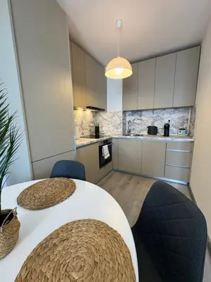 a kitchen with a white table and blue chairs at Ипанемма с 1 спальней корпус А in Sveti Vlas