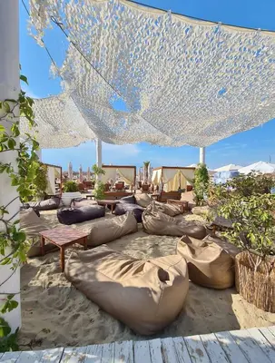 a group of bean bags on the sand under a tent at Kombani 3 in Sveti Vlas