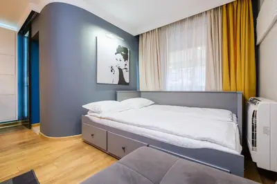 a bedroom with a bed and a blue wall at Sam Centre Harmony 1-Bedroom in Burgas City