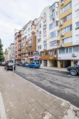 a city street with parked cars and buildings at Sam Centre Harmony 1-Bedroom in Burgas City
