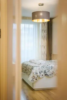 a bedroom with a bed with a window and a light at Sam Centre Harmony 1-Bedroom in Burgas City