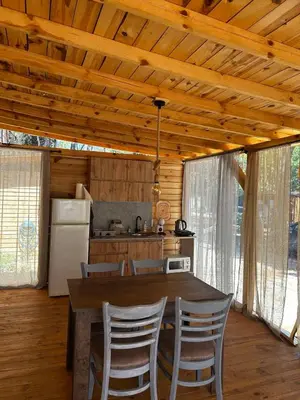 a kitchen with a wooden ceiling and a table and chairs at Каравана Рубин in Chernomorets