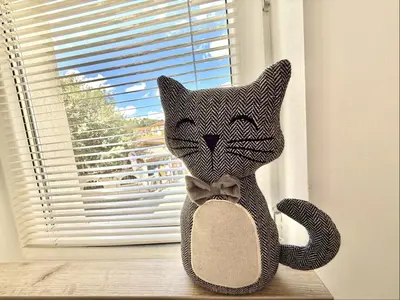 a stuffed cat sitting on a window sill at Carina Beach - Menada Apartments in Sunny Beach