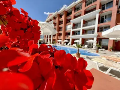 a bunch of red flowers in front of a hotel at Carina Beach - Menada Apartments in Sunny Beach
