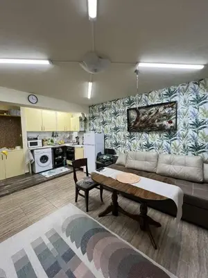 a living room with a couch and a table at Апартамент Боги in Burgas City