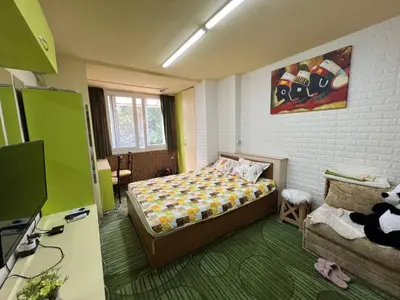 a small bedroom with a bed and a couch at Апартамент Боги in Burgas City