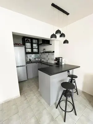 a kitchen with a counter and two bar stools at Cozy apartment at the heart of Burgas in Burgas City