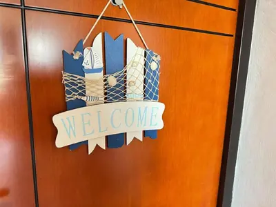 a welcome sign is hanging on a door at Линоляни in Pomorie
