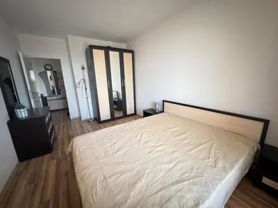a bedroom with a large bed and wooden floors at Линоляни in Pomorie
