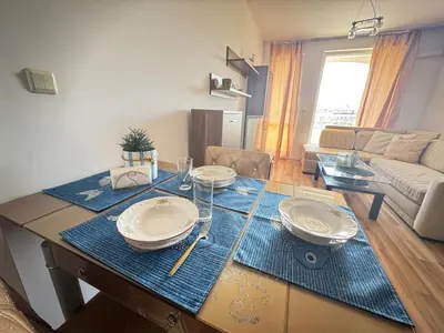 a living room with a table with plates on it at Линоляни in Pomorie
