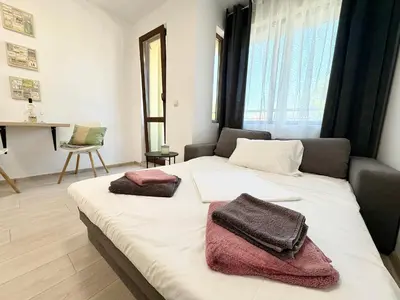 a bedroom with a bed with two towels on it at Sweet tiny house-central studio in Varna City