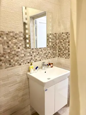 a bathroom with a white sink and a mirror at Sweet tiny house-central studio in Varna City