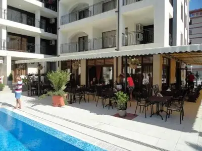 a person standing next to a swimming pool in a hotel at Luxury Studio B02 SB in Sunny Beach